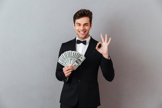 Hombre joven feliz con dinero.