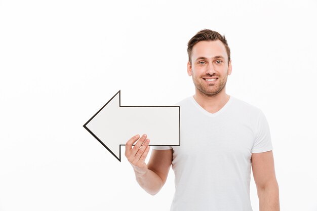 Hombre joven feliz emocional que sostiene la flecha