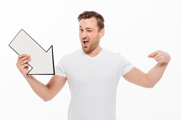 Hombre joven feliz emocional que sostiene la flecha