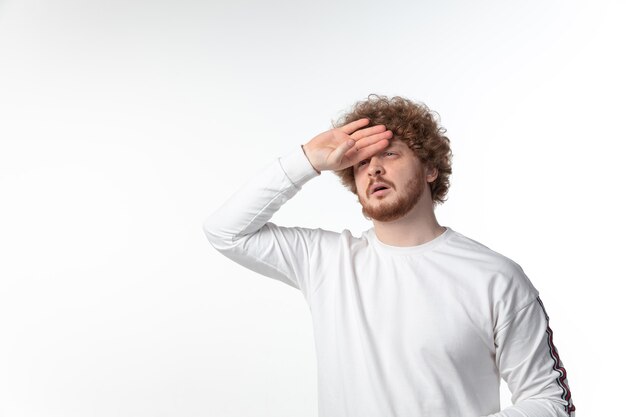 Hombre joven con fiebre en la pared blanca