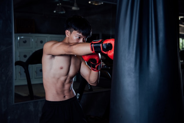 hombre joven fuerte deportes hombre boxeador hacer ejercicios en el gimnasio, concepto saludable