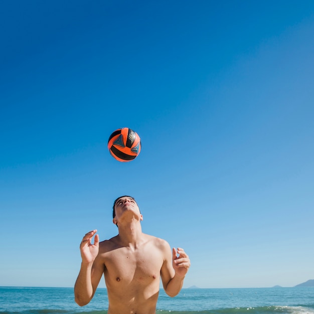 Foto gratuita hombre joven en fútbol playa