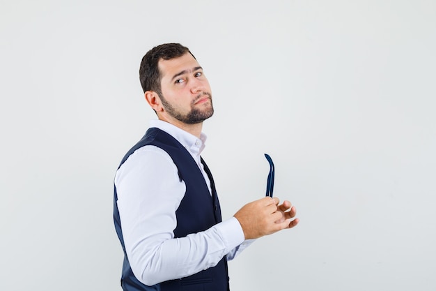 Hombre joven con gafas en camisa, chaleco y guapo. .