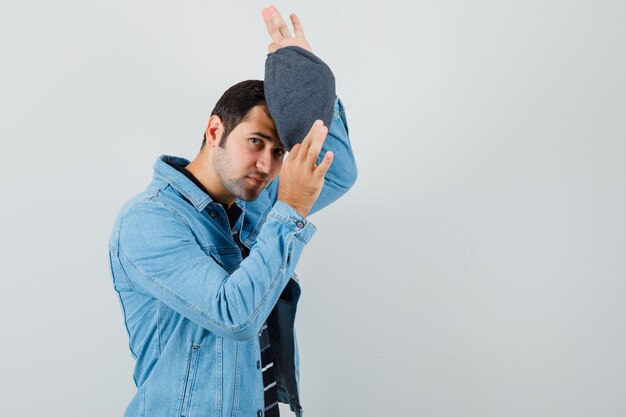 Hombre joven con gorra en la chaqueta, vista frontal de la camiseta. espacio para texto