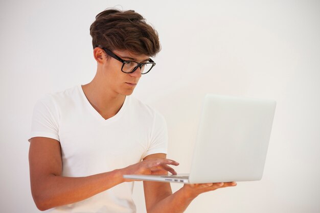 Hombre joven guapo con computadora