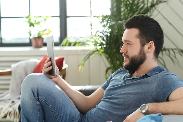 Hombre joven guapo con tableta digital o libro electrónico