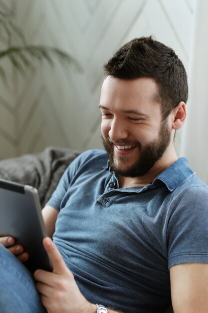 Hombre joven guapo con tableta digital o libro electrónico