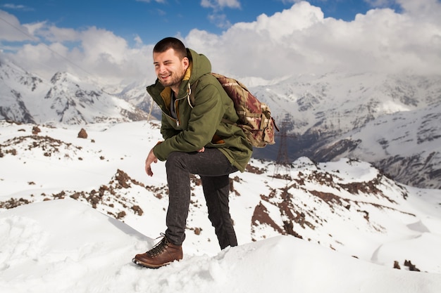 Hombre joven inconformista senderismo en las montañas, viajes de vacaciones de invierno