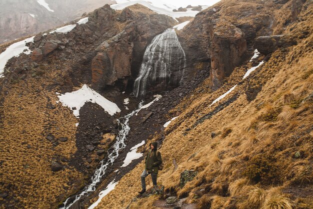 Hombre joven inconformista senderismo en las montañas, viajes de vacaciones de otoño