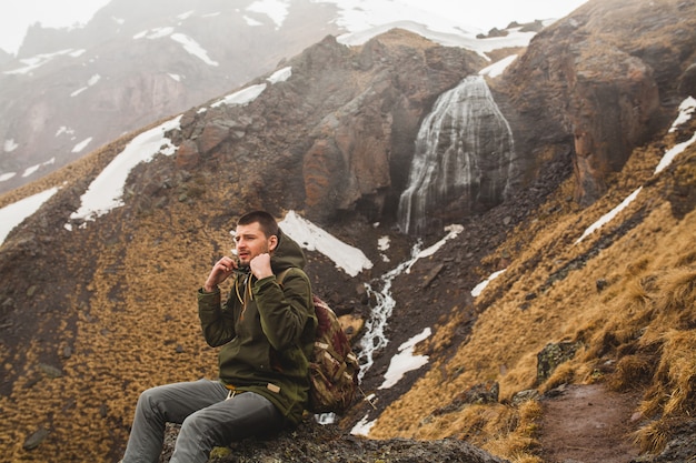 Hombre joven inconformista senderismo en las montañas, viajes de vacaciones de otoño