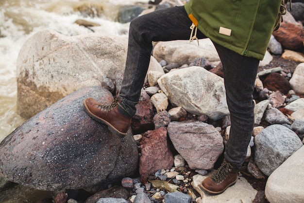 Hombre joven inconformista, senderismo en la naturaleza salvaje, vacaciones de invierno, viajes, zapatos calientes, botas de cerca, detalles pies, piernas