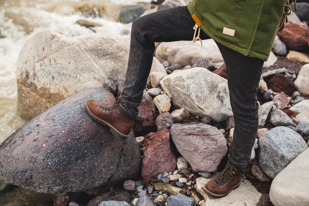 Hombre joven inconformista, senderismo en la naturaleza salvaje, vacaciones de invierno, viajes, zapatos calientes, botas de cerca, detalles pies, piernas