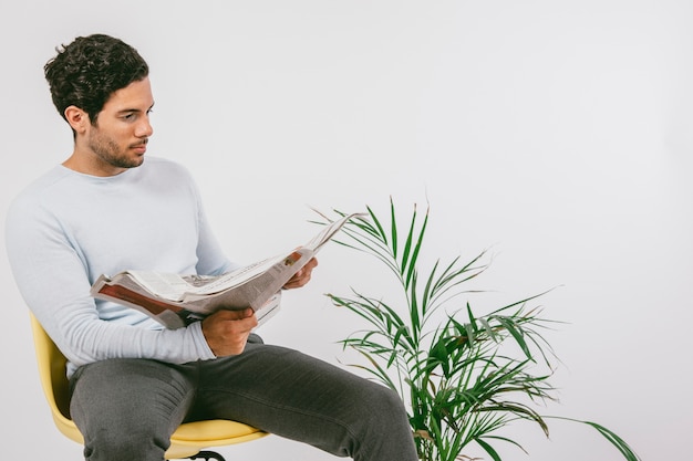 Foto gratuita hombre joven leyendo el periódico