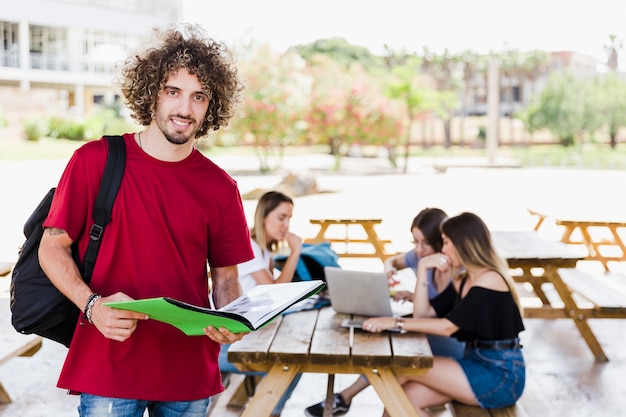 Hombre joven con el libro que mira la cámara