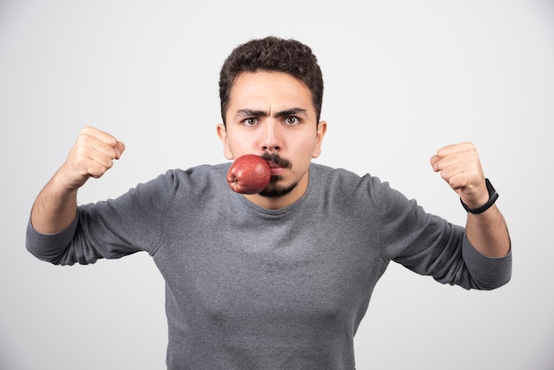 Hombre joven con manzana en la boca y listo para perforar.