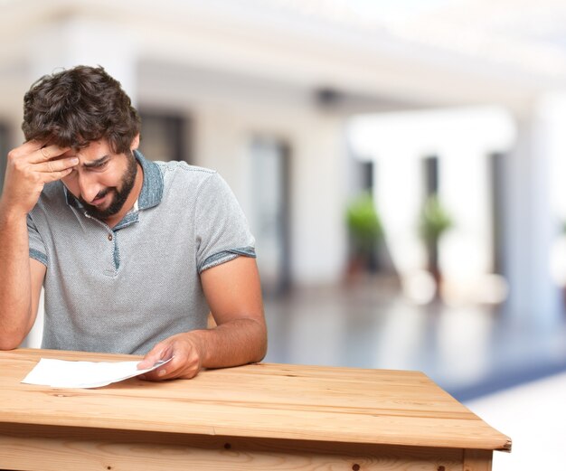 hombre joven en una mesa. expresión de preocupación