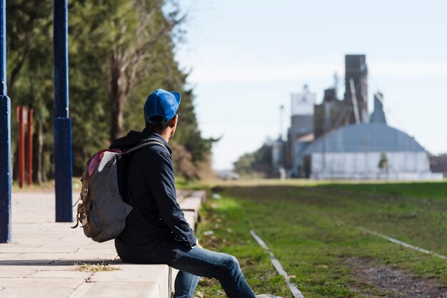 Hombre joven con mochila mirando a otro lado