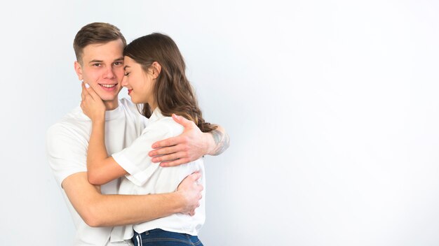 Hombre joven en mujer abrazando blanco
