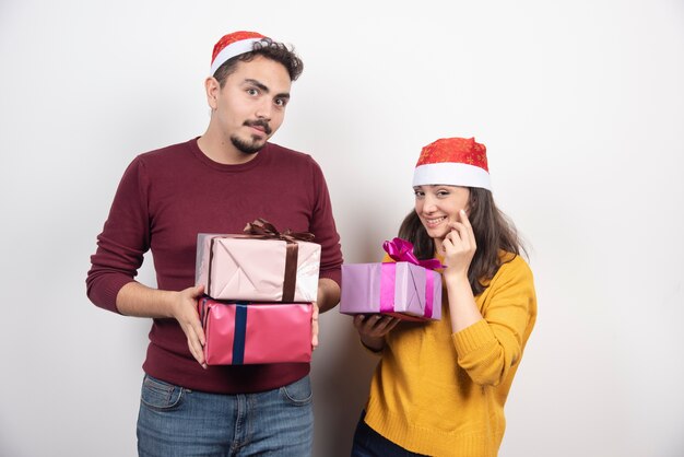 Hombre joven con mujer posando con regalos de Navidad.