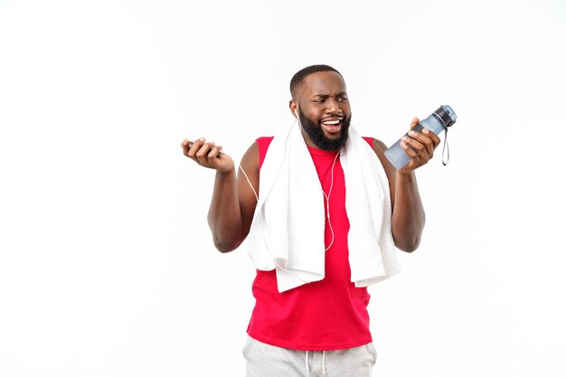 Hombre joven musculoso mantenga agua de la botella después de correr, atleta atractivo descansando después del entrenamiento al aire libre, fitness y concepto de estilo de vida saludable. Aislado en blanco.