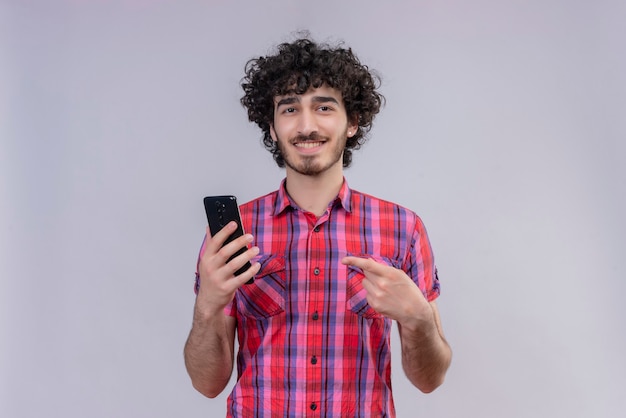 Hombre joven con pelo rizado aislado camisa colorida smartphone apuntando 2