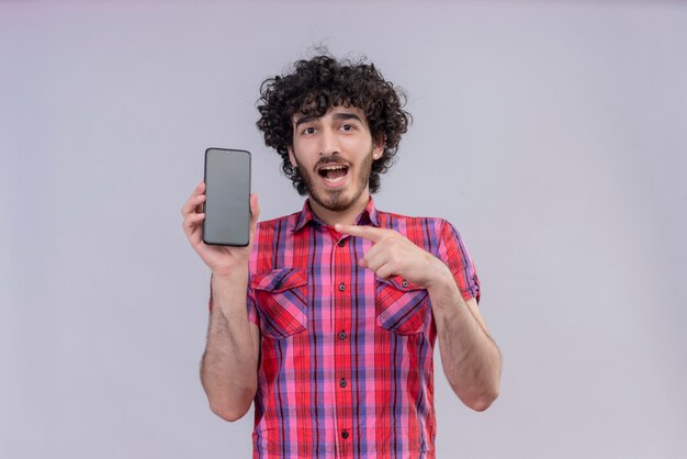 Hombre joven con pelo rizado aislado camisa colorida smartphone apuntando