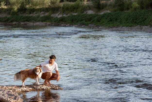 Hombre joven con perro en la playa