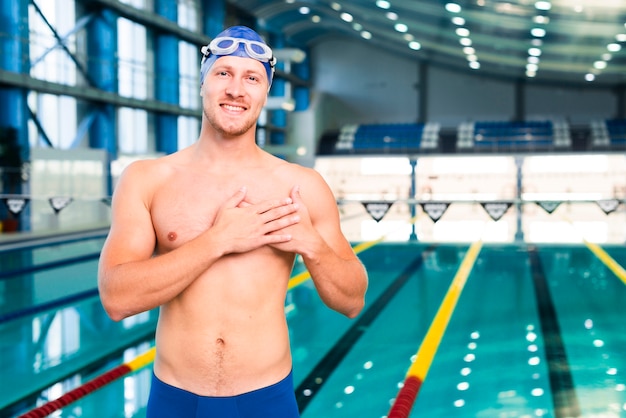 Hombre joven en la piscina con gafas