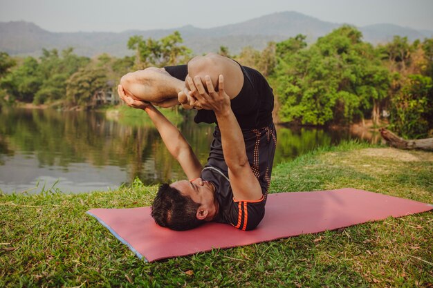 Hombre joven en postura de yoga de expertos