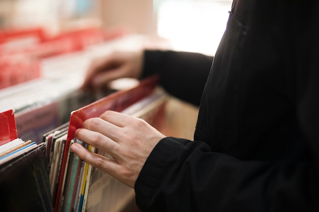 Hombre joven del primer que busca vinilos en tienda