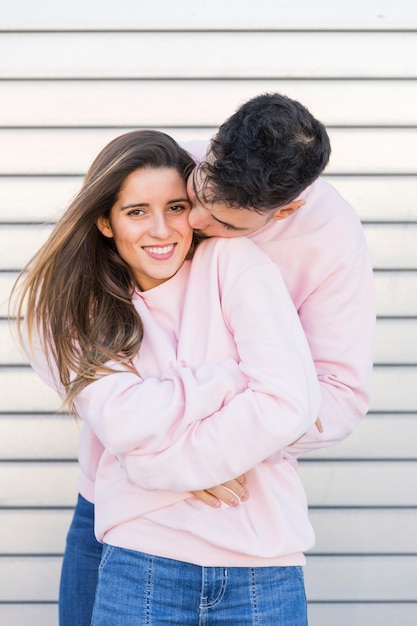 Foto gratuita hombre joven que besa y que abraza a la mujer feliz atractiva