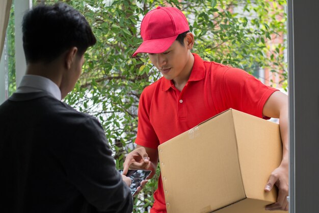 Hombre joven que entrega el paquete al cliente en casa. Entrega