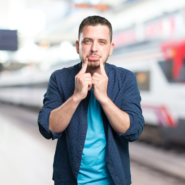 El hombre joven que llevaba un traje azul. Cara triste.