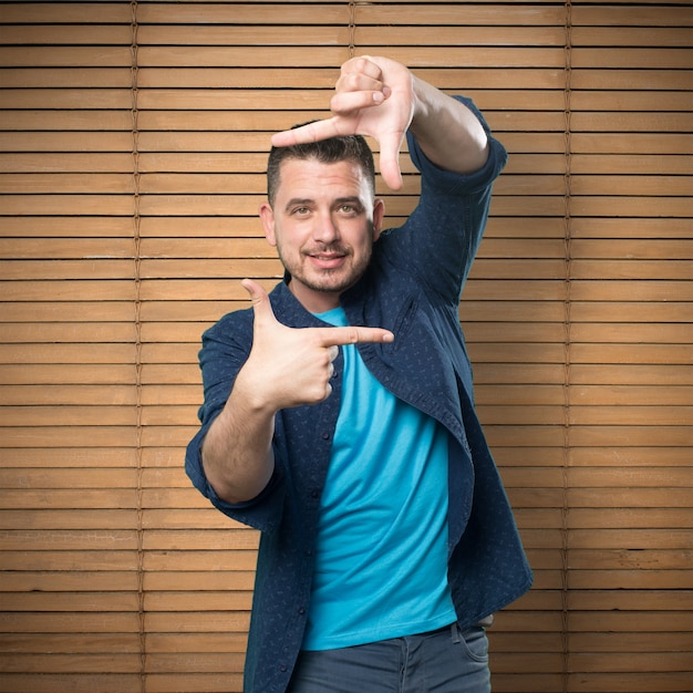 El hombre joven que llevaba un traje azul. Haciendo forma de la montura.