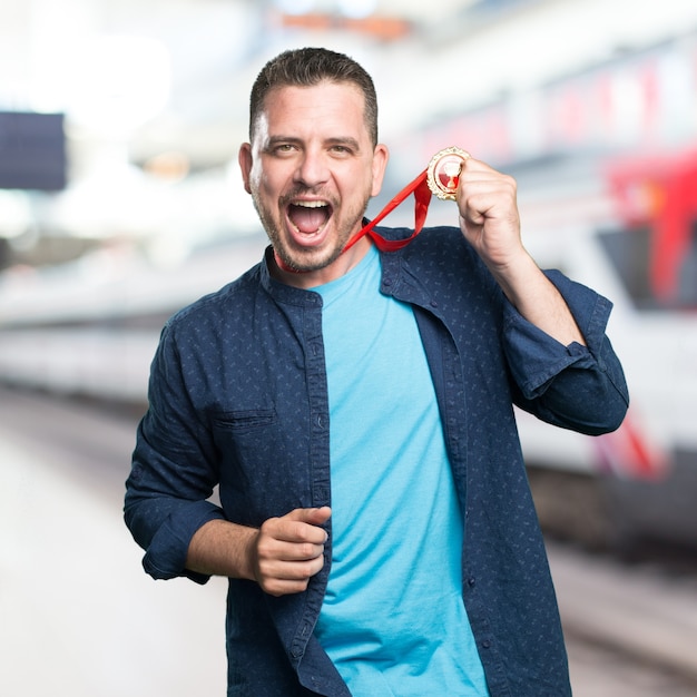 Foto gratuita el hombre joven que llevaba un traje azul. con una medalla de oro.