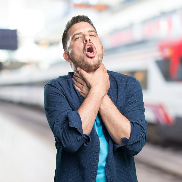 El hombre joven que llevaba un traje azul. Tienes la garganta.