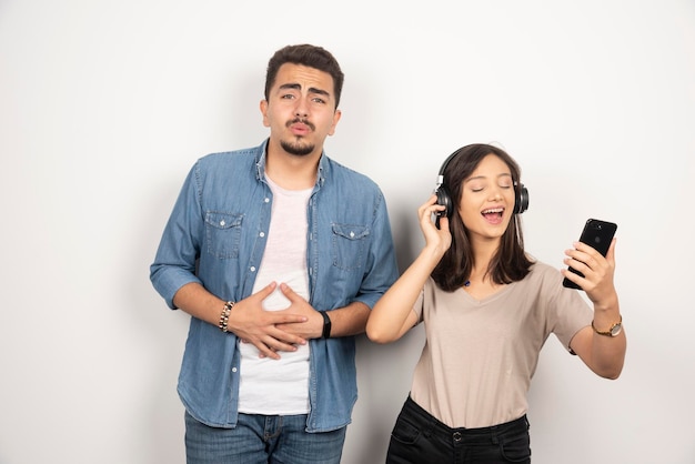 Hombre joven que se siente deprimido mientras la mujer canta una canción.