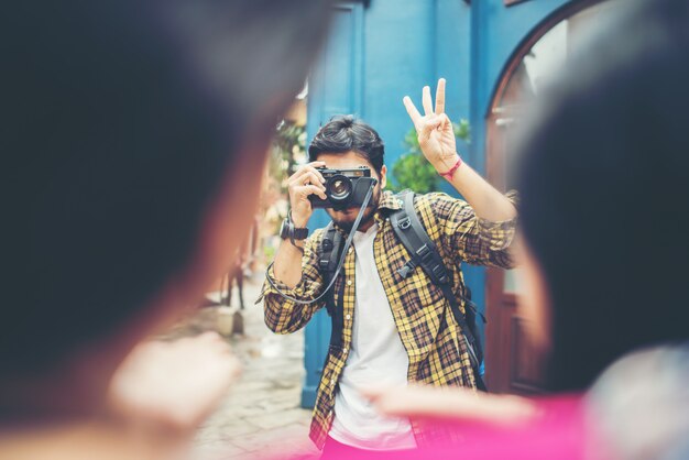 Hombre joven que toma el selfie de sus amigos mientras viaja en urbano juntos.