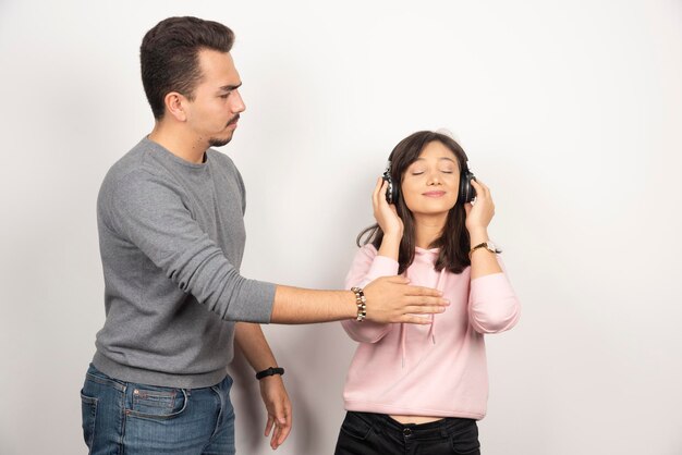 El hombre joven quiere detener a la mujer con auriculares.