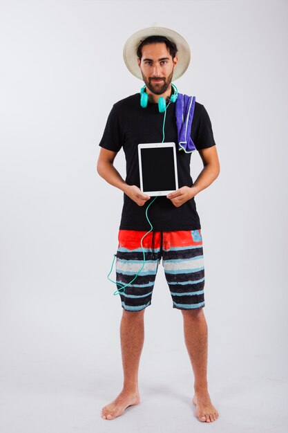 Hombre joven en ropa de verano sujetando tablet