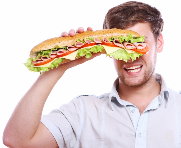 Foto gratuita hombre joven con sándwich grande