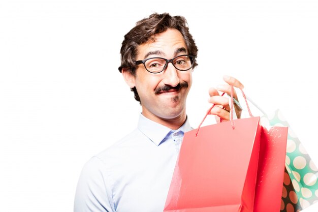 Hombre joven satisfecho mostrando sus bolsas de la compra