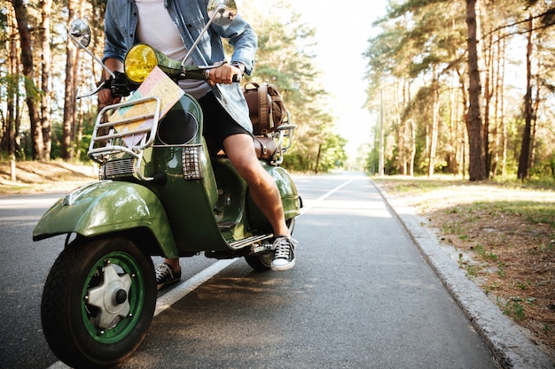 Foto gratuita hombre joven en scooter al aire libre.