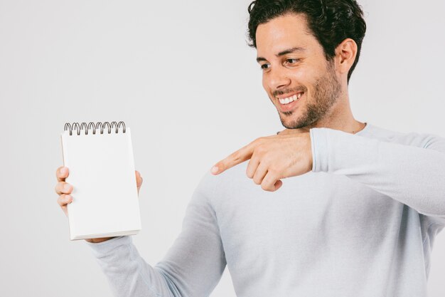 Hombre joven señalando la libreta