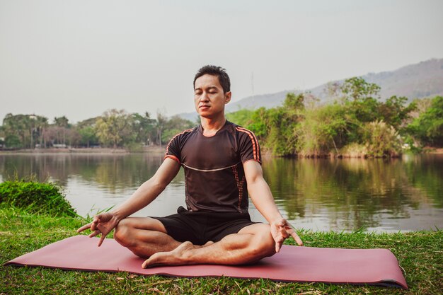 Hombre joven sentado y meditando