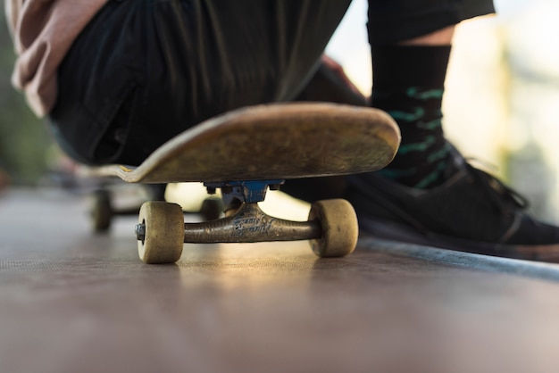 Hombre joven sentado sobre patineta