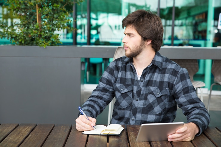Foto gratuito hombre joven serio que usa la aplicación financiera