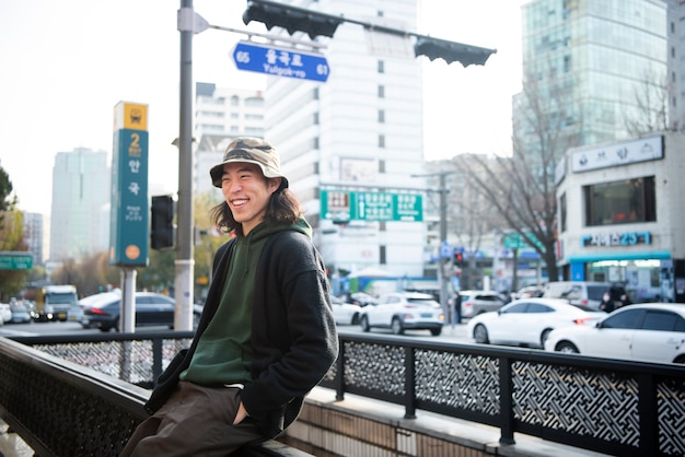 Foto gratuita hombre joven con un sombrero de cubo en la ciudad