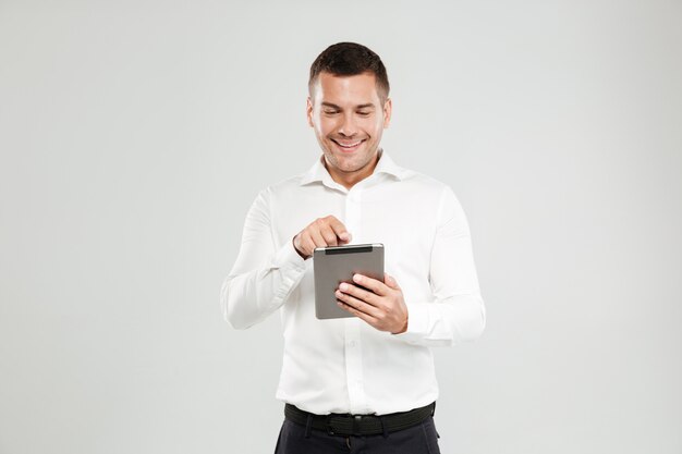 Hombre joven sonriente que charla por la tableta.