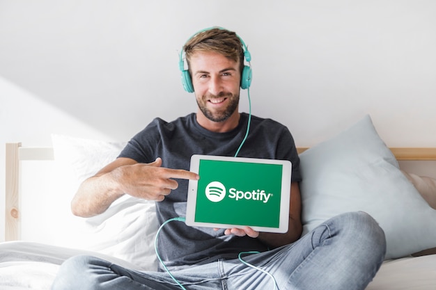 Hombre joven sosteniendo tablet con la app de spotify